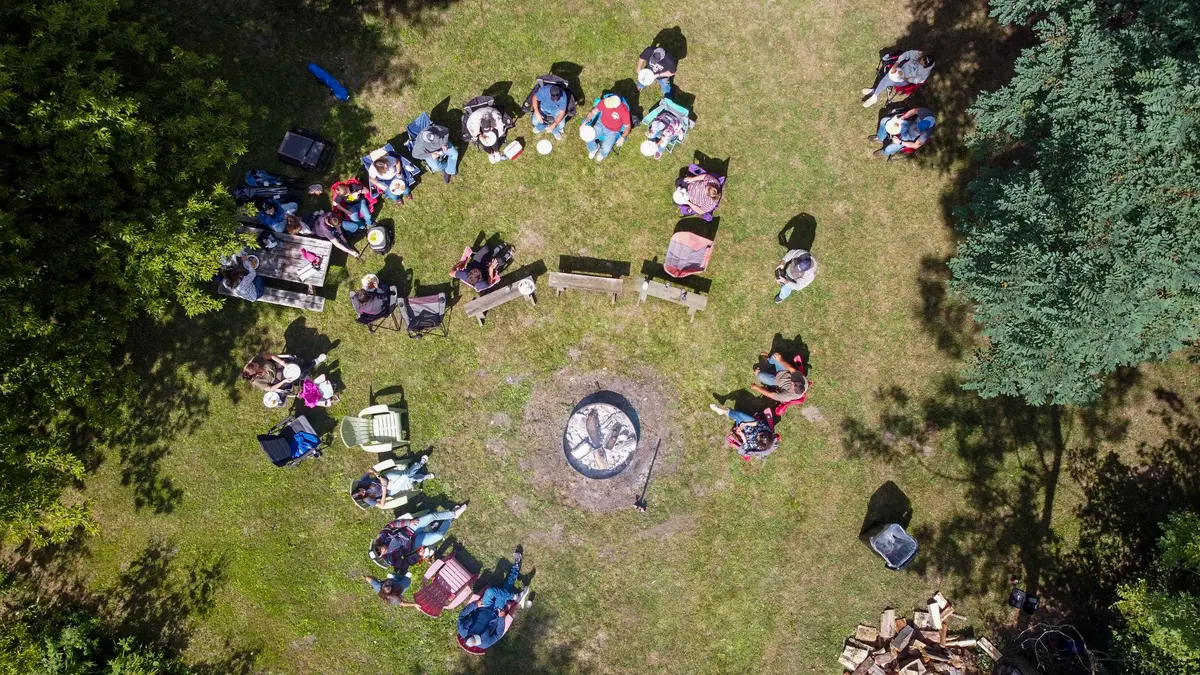 Aerial view of a hunting camp gathered around a fire